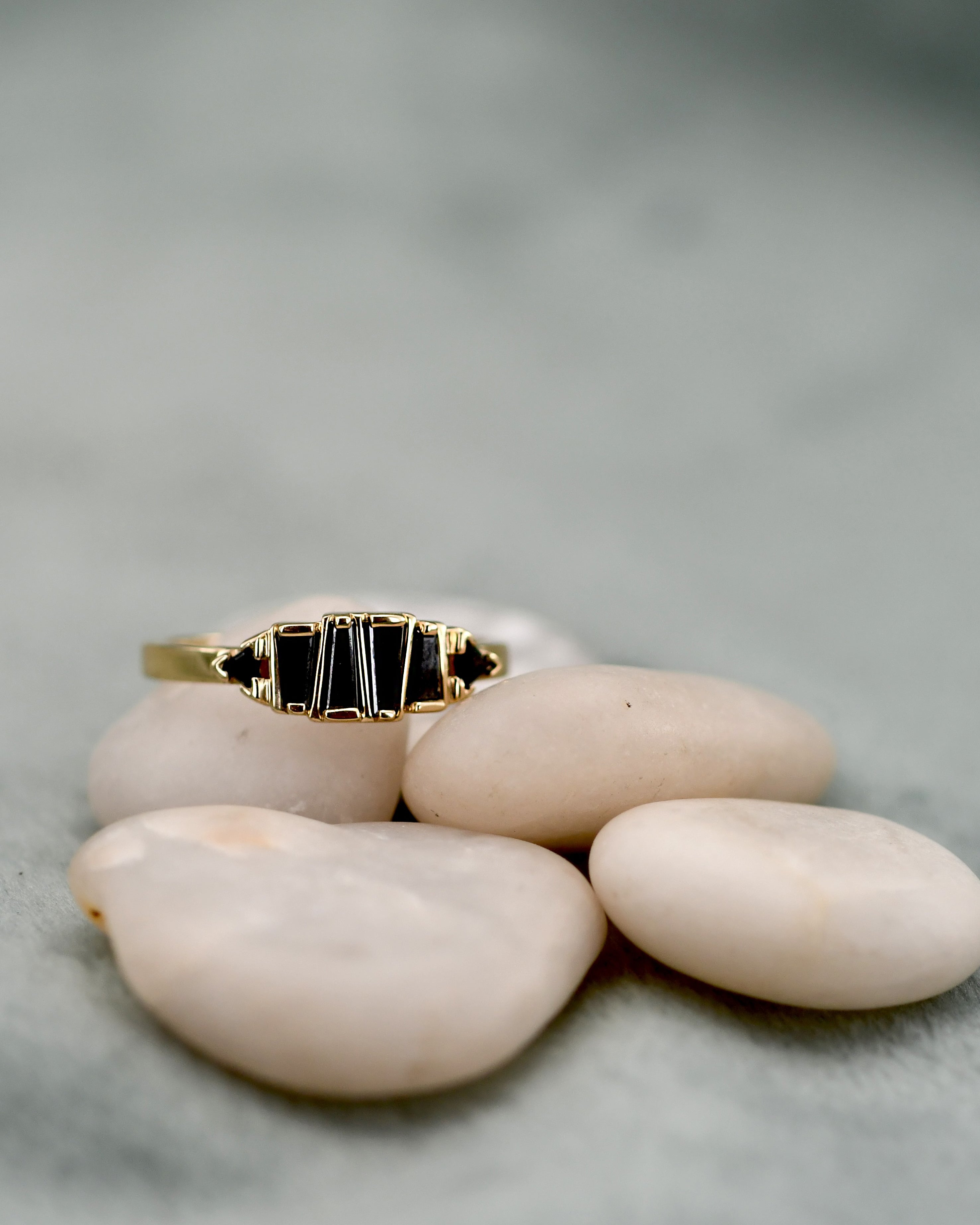 A gold ring with six black rectangular black diamonds, 