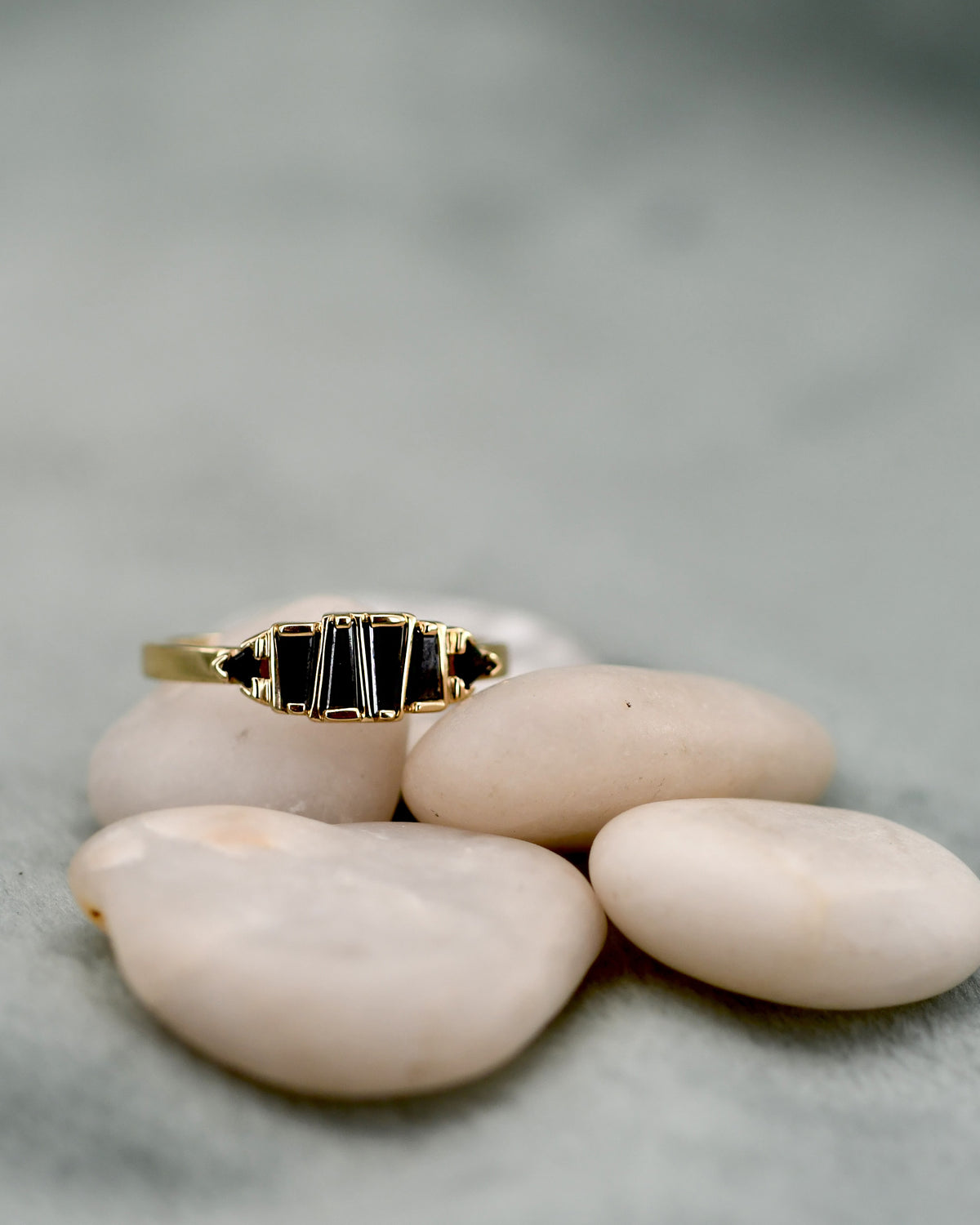 A gold ring with six black rectangular black diamonds, 
