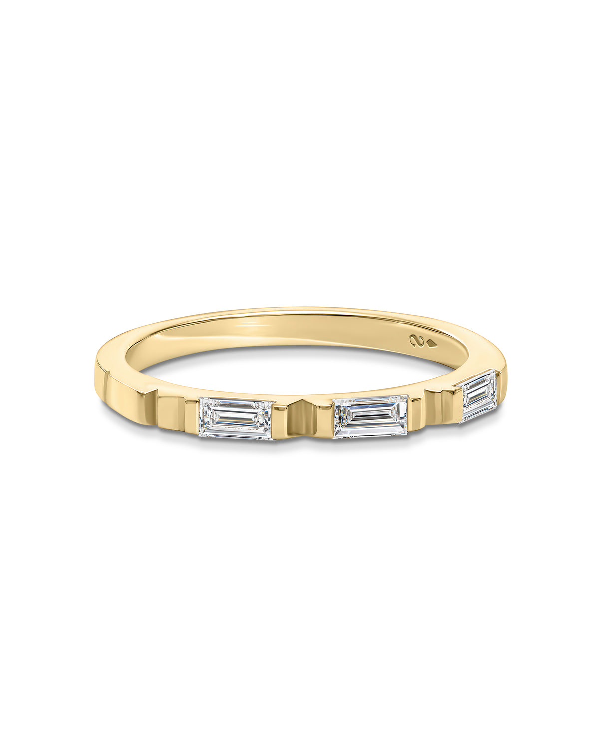 A yellow gold band ring featuring a row of baguette-cut clear stones on the front, photographed against a plain white background.