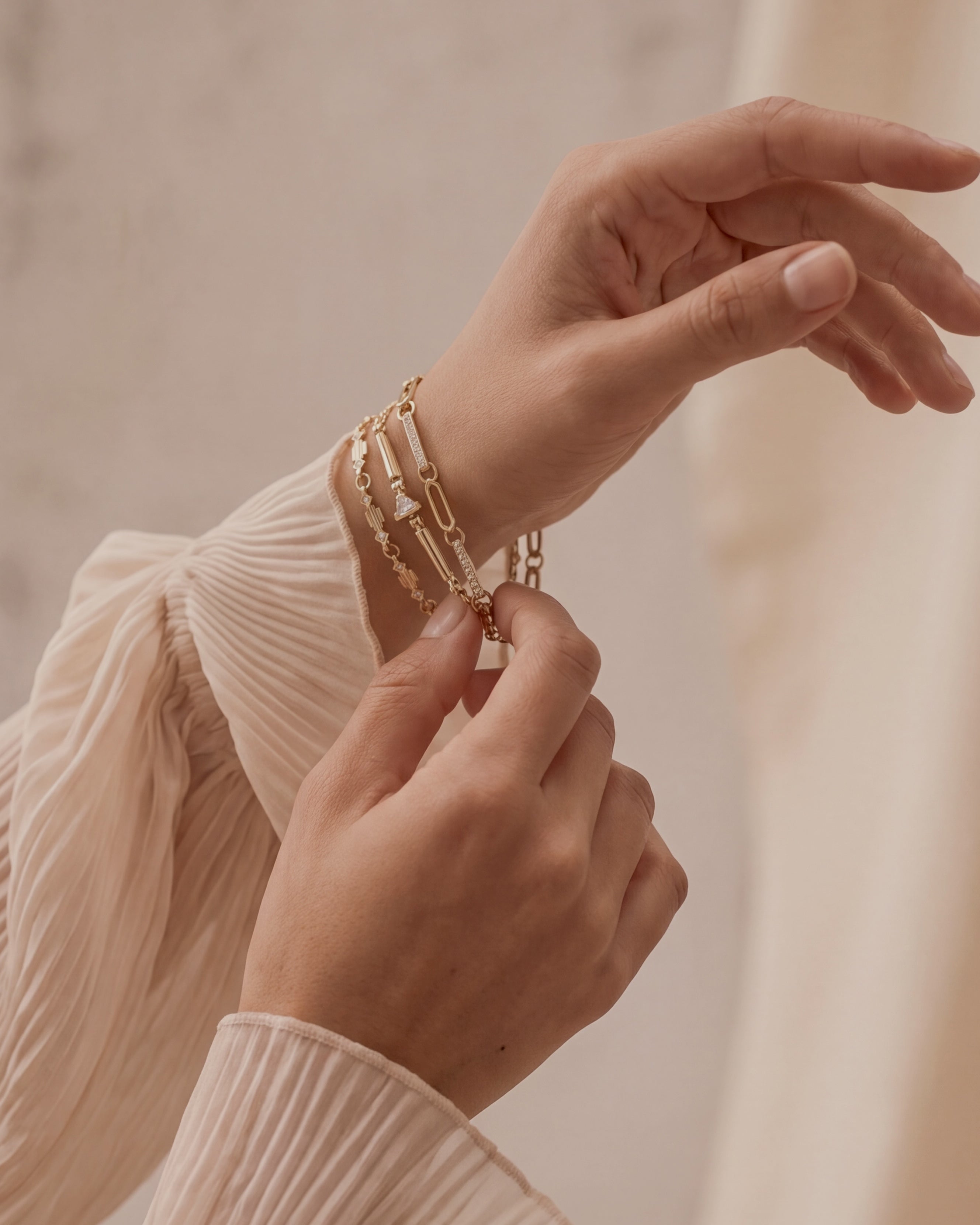 three gold and diamond bracelets on hand