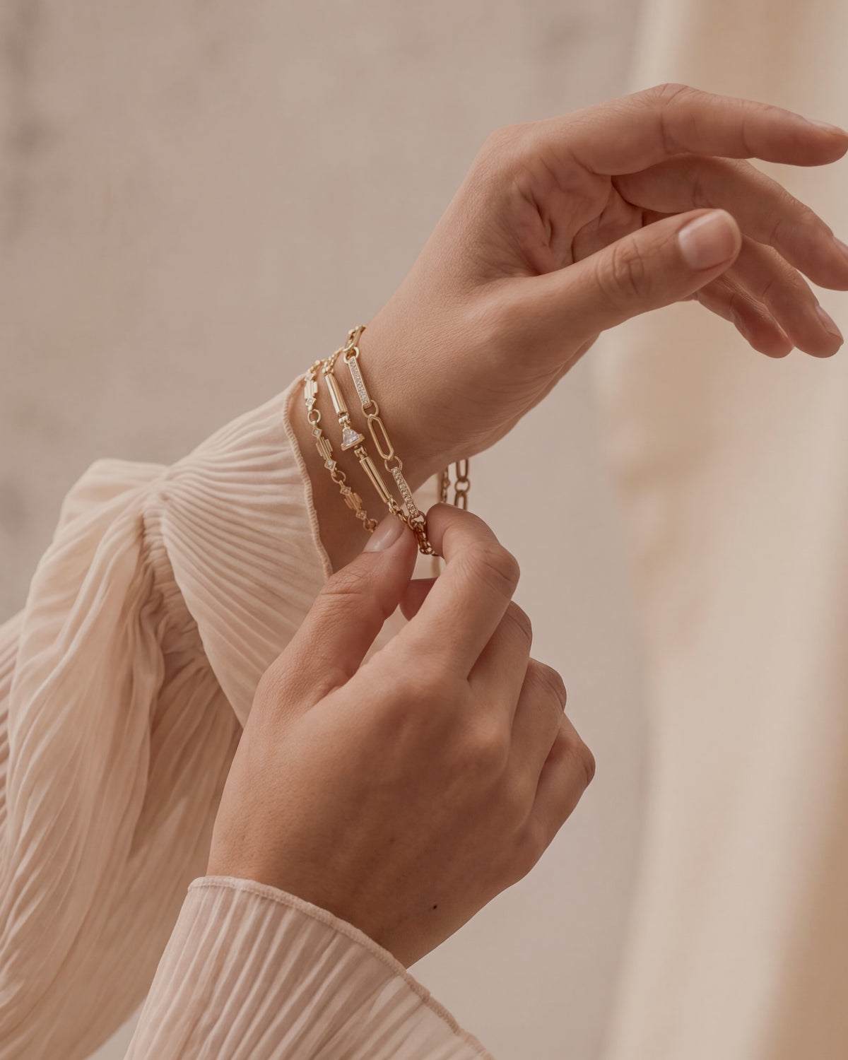 three gold and diamond bracelets on hand