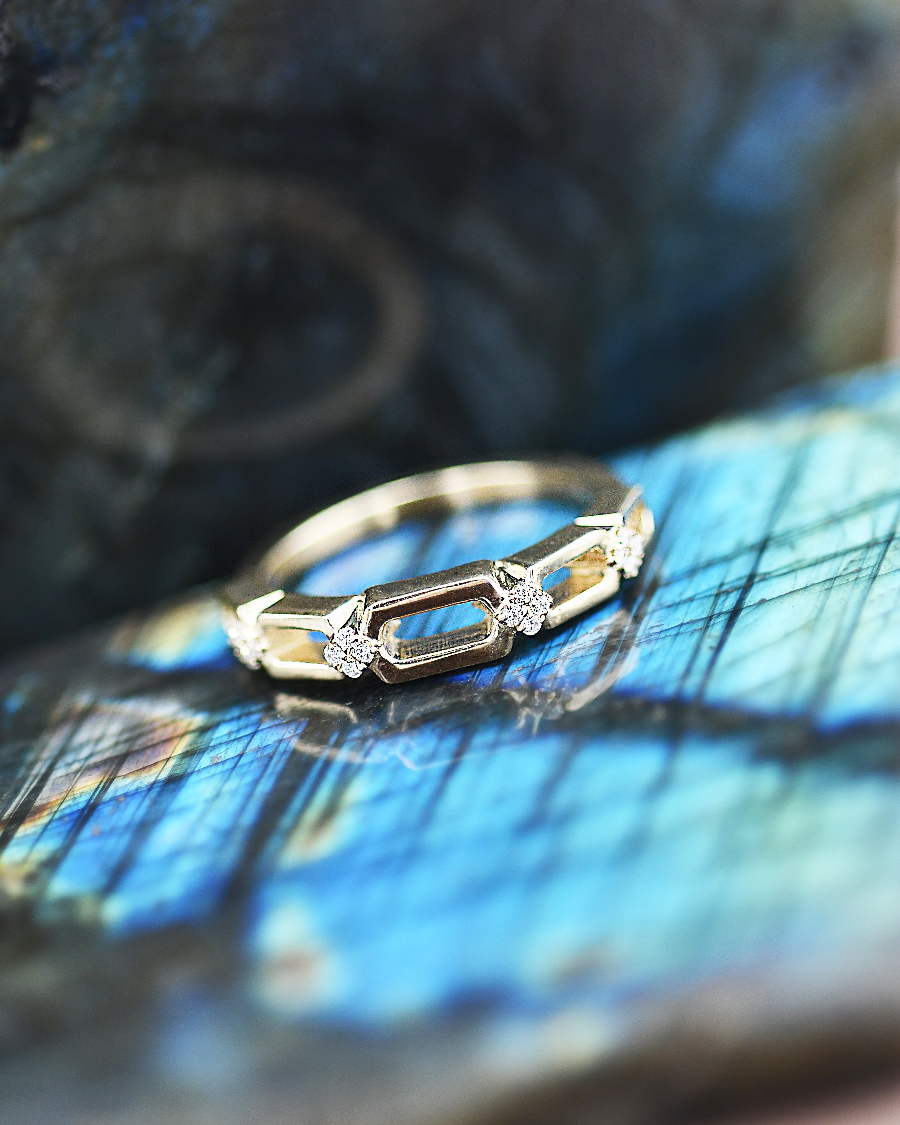 Gold ring with diamonds on a textured blue surface