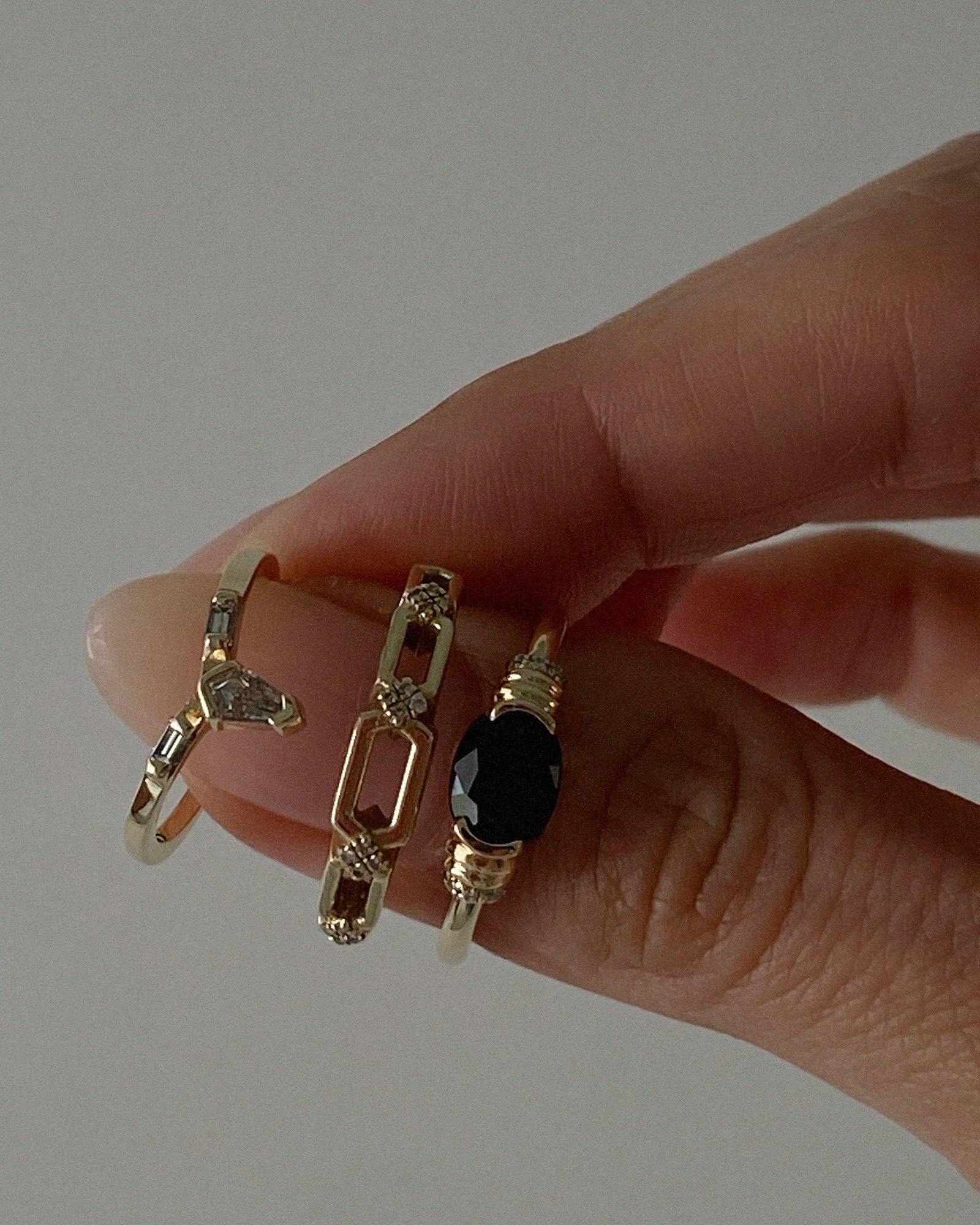 gold rings with diamonds and gemstones on hand