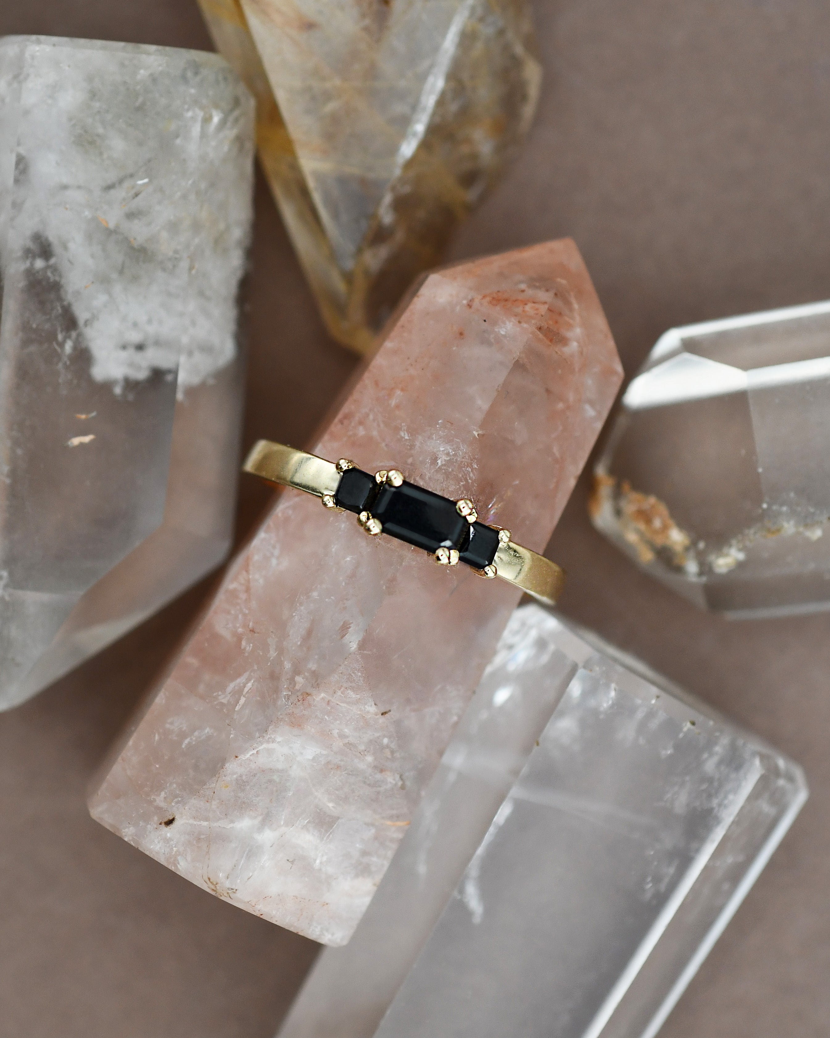 Gold ring with black diamonds on a crystal surface