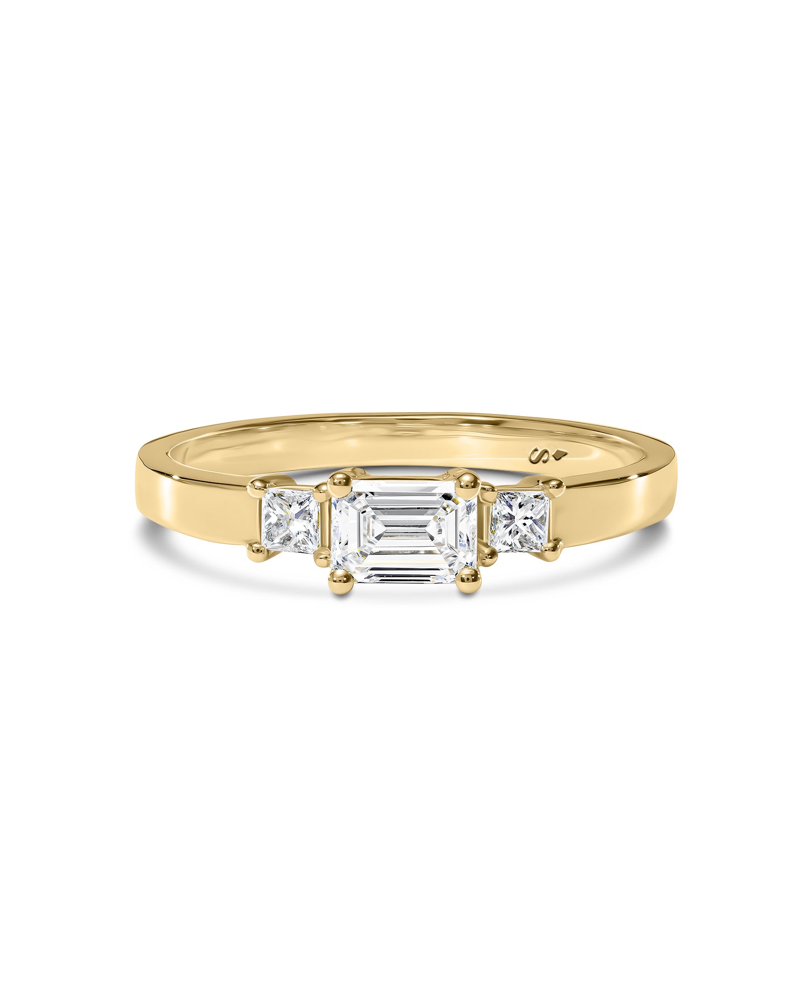 Gold ring with three white diamonds on a white background
