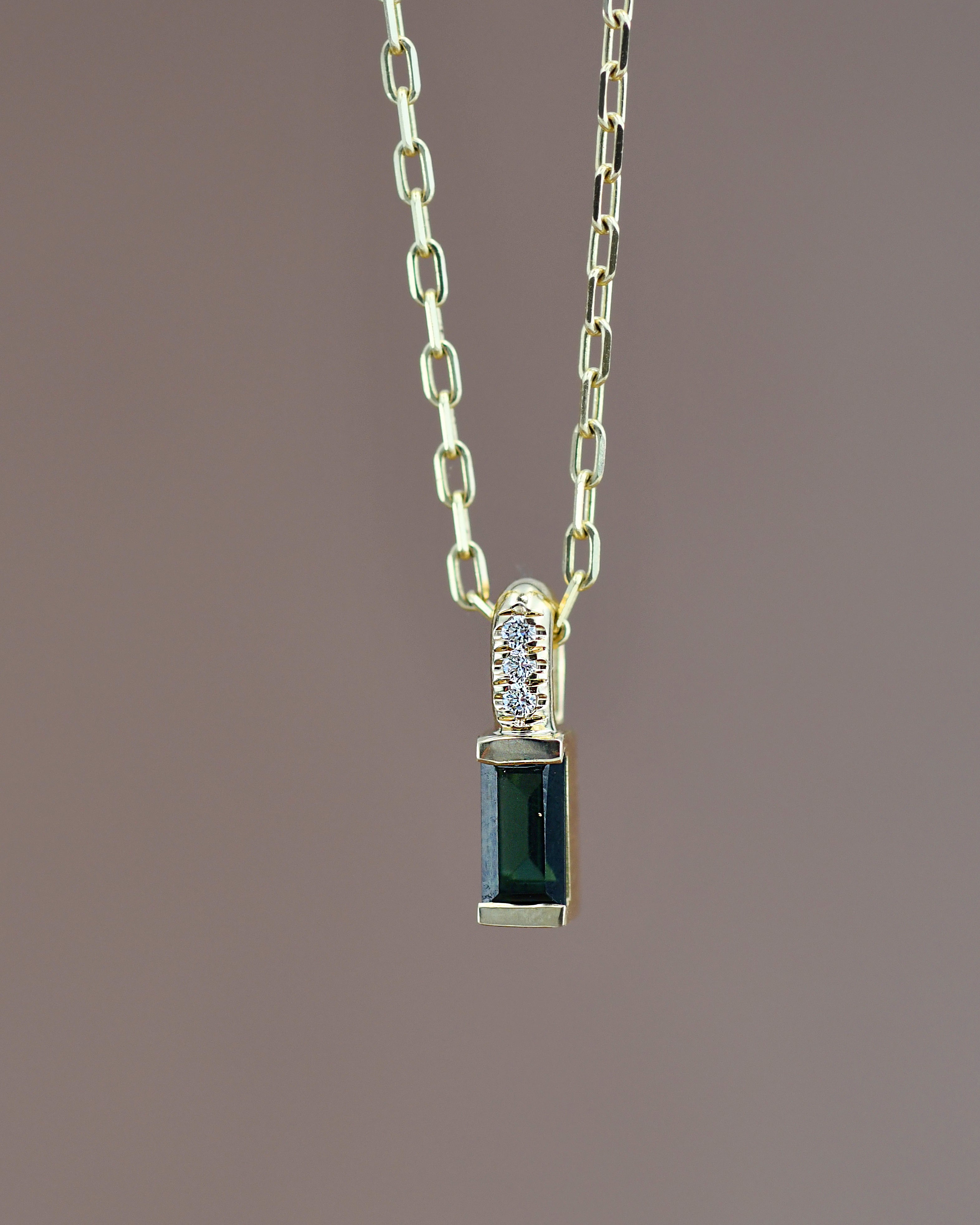 Gold necklace with a green gemstone pendant 