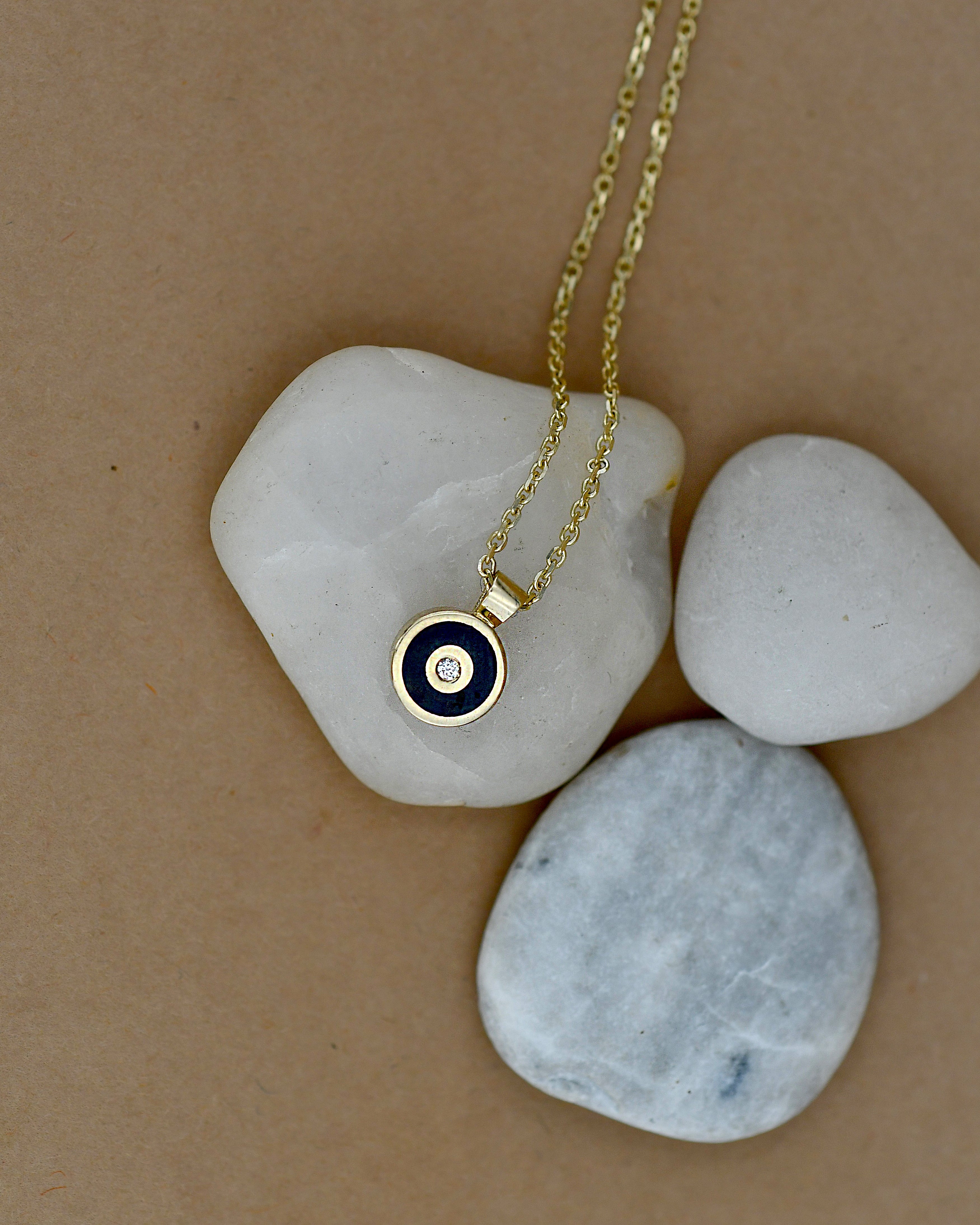 Gold necklace with a blue pendant and white diamond