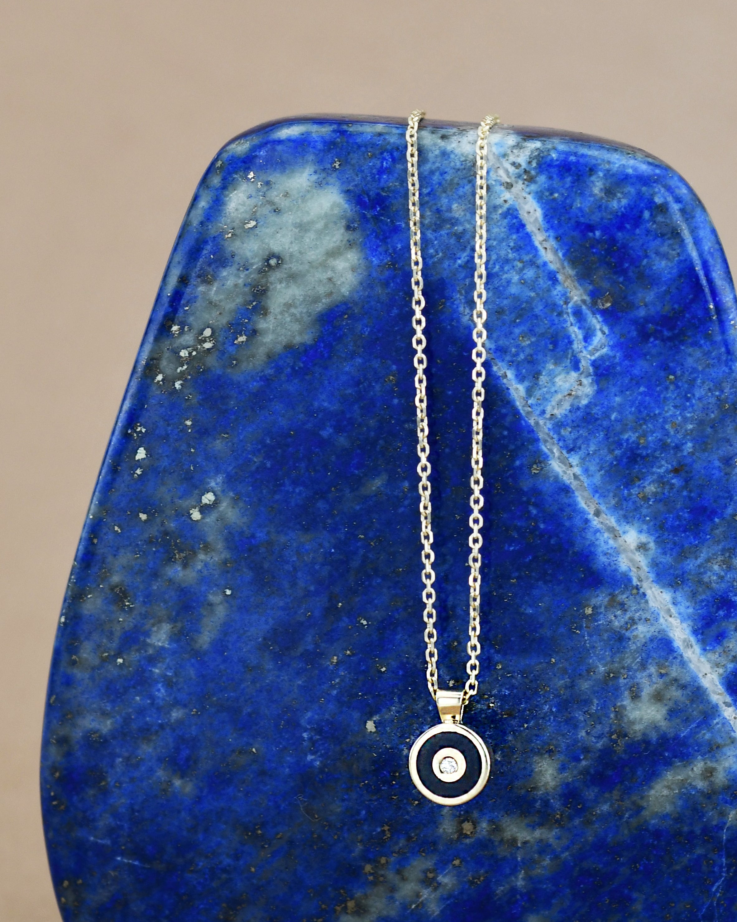 Necklace with a circular blue pendant and white diamond 
