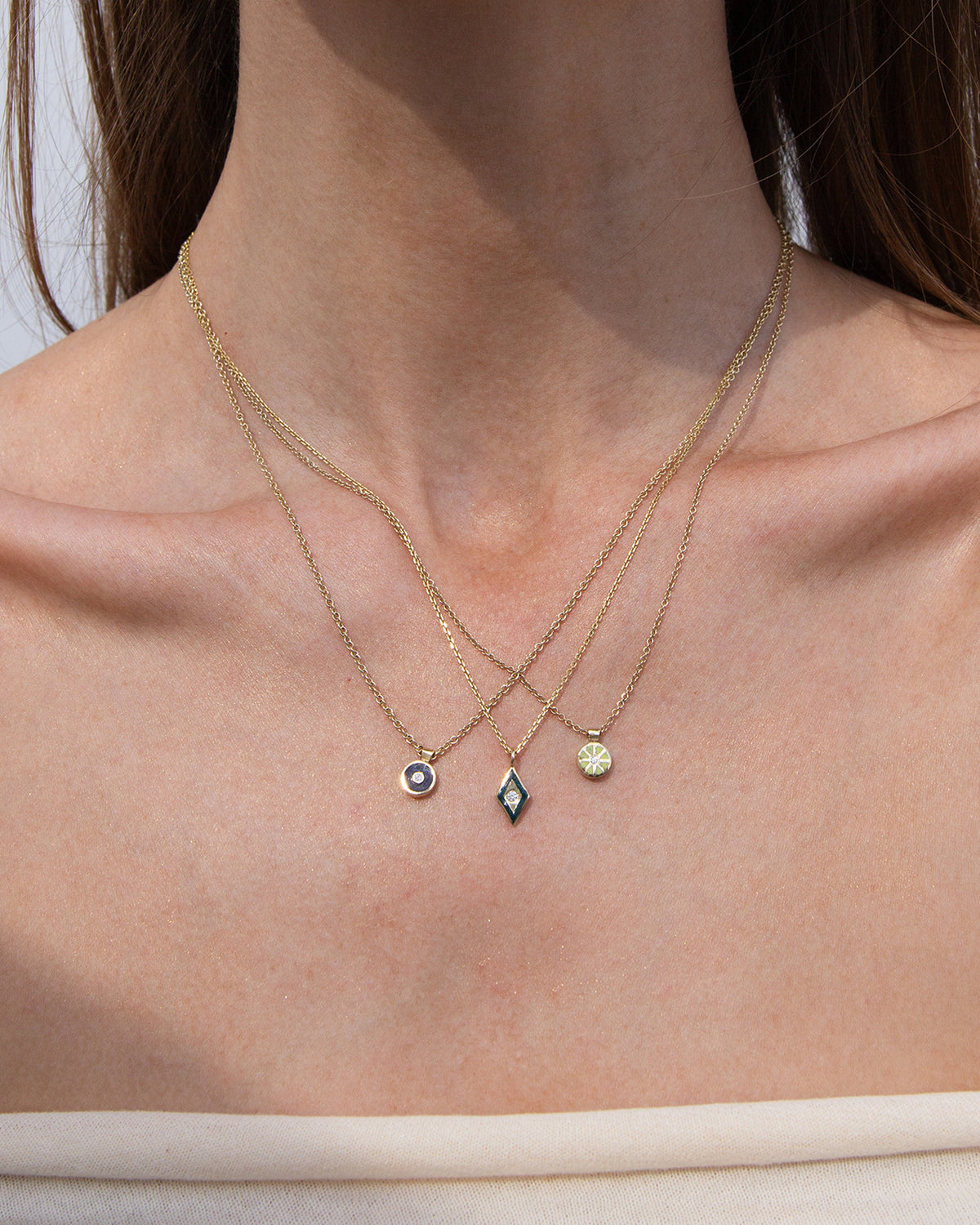 Gold necklace with a blue, yellow and green pendant and white diamond