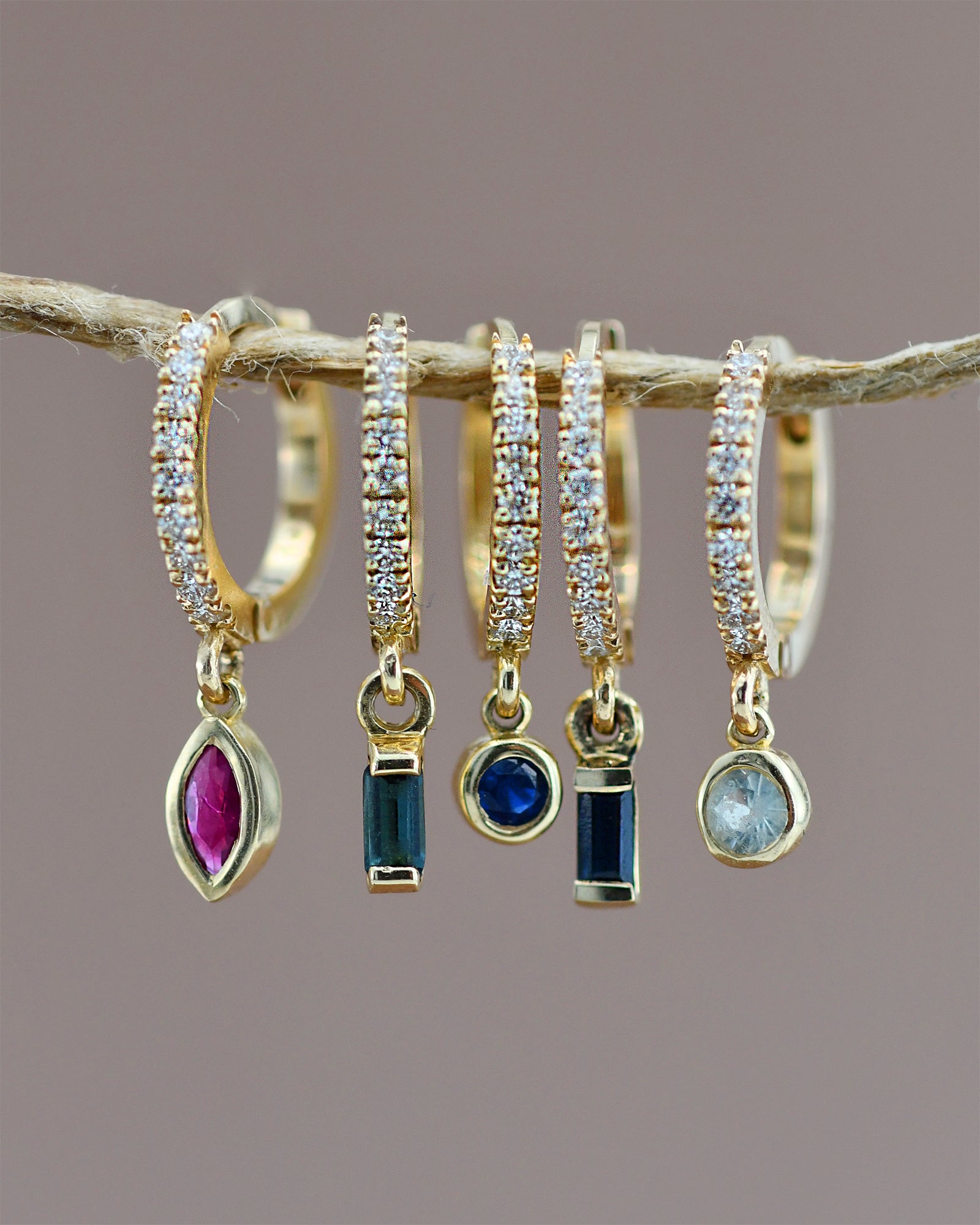 Set of gold hoop earrings with gemstone drops 