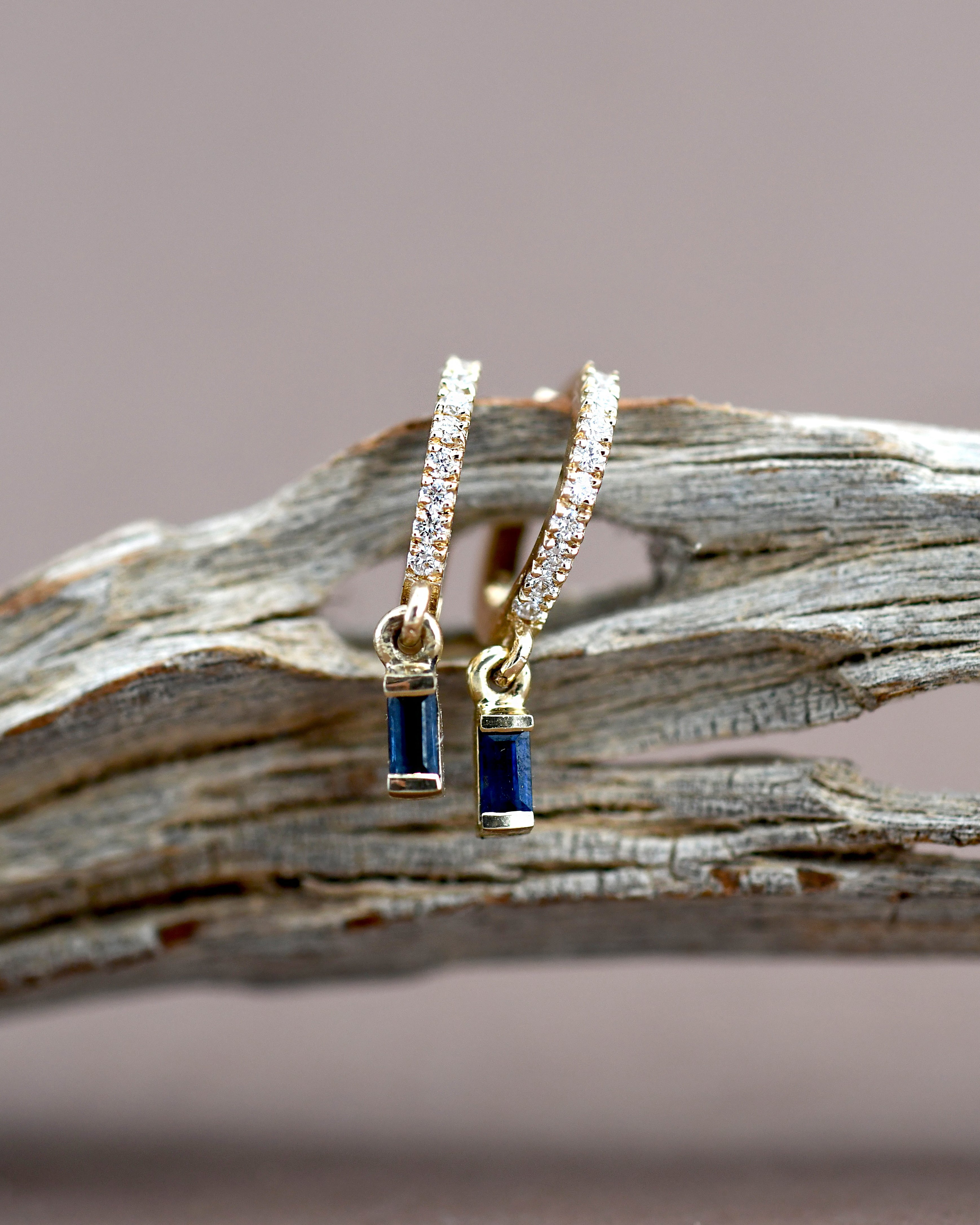 Pair of gold hoop earrings with blue gemstones 