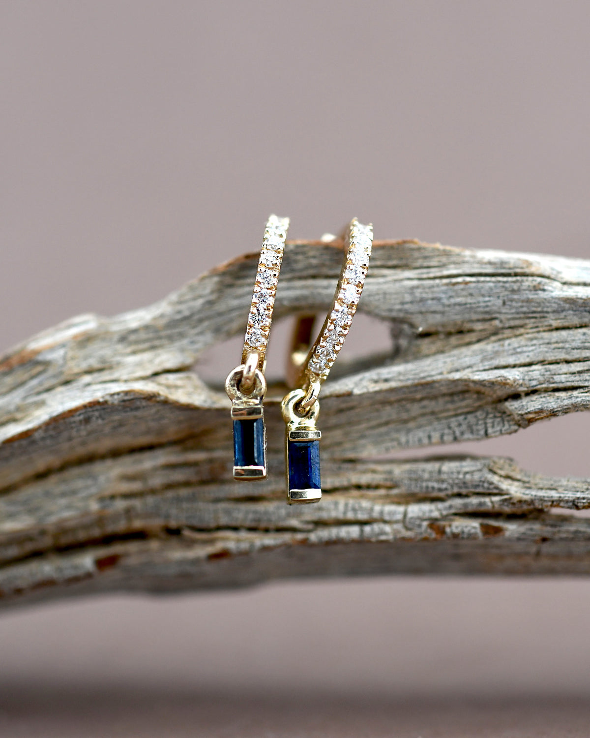 Pair of gold hoop earrings with blue gemstones 