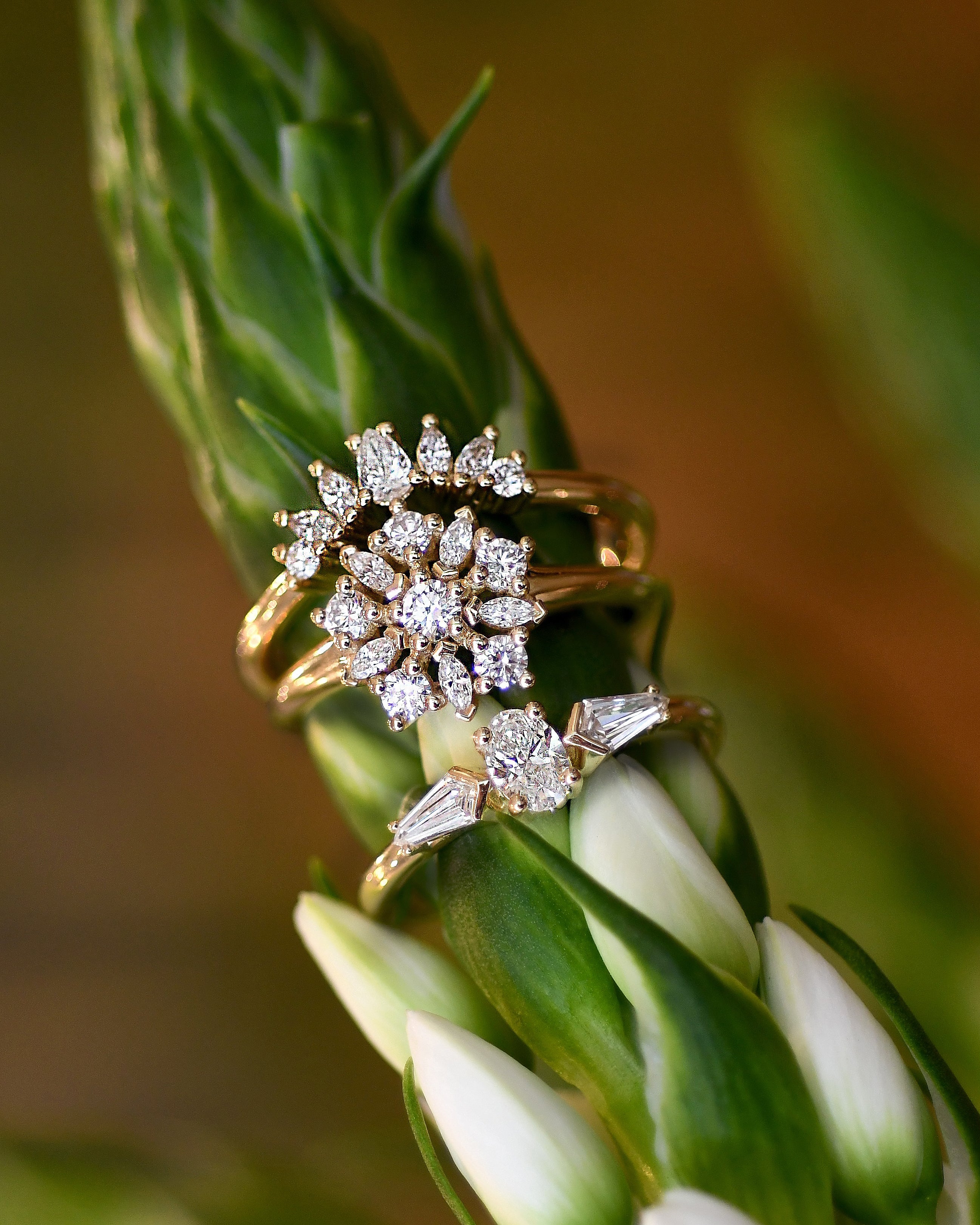 3 gold rings with diamonds on flower